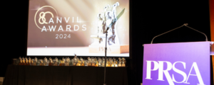 The title slide for the 80th Annual Anvil Awards lights up a room beside a PRSA-branded podium.